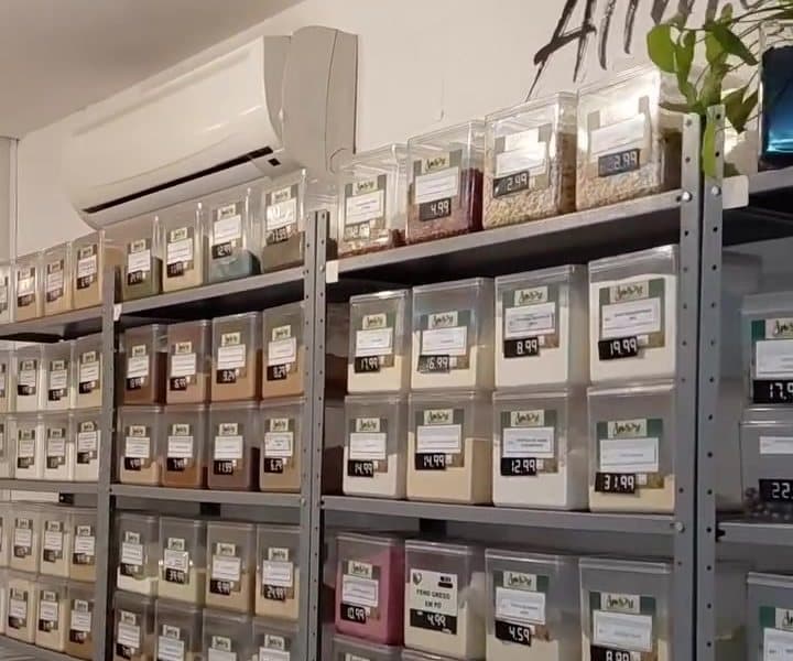 Estantes de aço com fileiras de potes de acrílico, cada um com a etiqueta do produto